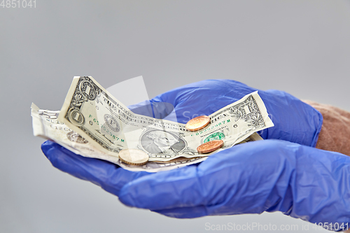 Image of close up of hands in medical gloves with money