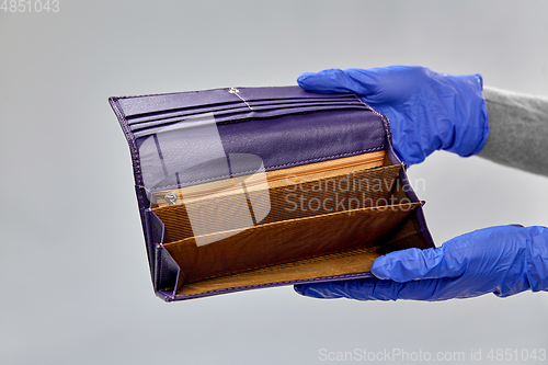 Image of close up of hands in gloves with empty wallet