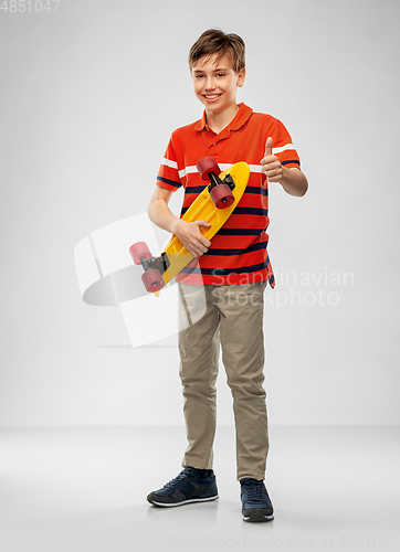 Image of smiling boy with short skateboard