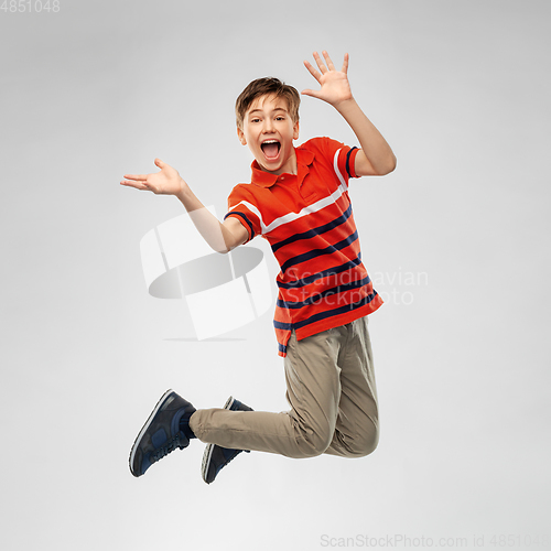 Image of happy smiling young boy jumping in air