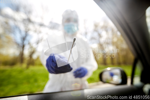 Image of healthcare worker making coronavirus test at car