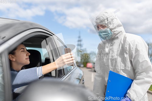 Image of woman in car showing phohe to healthcare worker