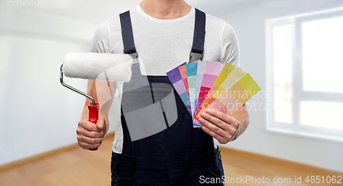 Image of close up of painter with roller and color charts