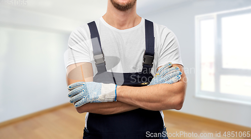 Image of close up of male builder in overall and gloves