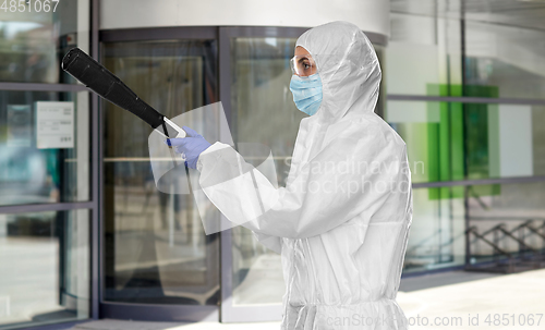 Image of sanitation worker in hazmat with pressure washer