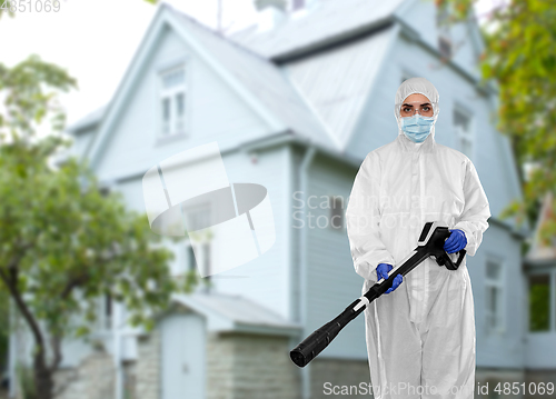 Image of sanitation worker in hazmat with pressure washer