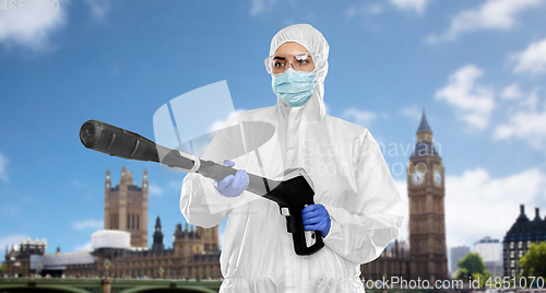 Image of sanitation worker in hazmat with pressure washer