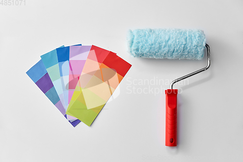 Image of paint roller and color palette on white background