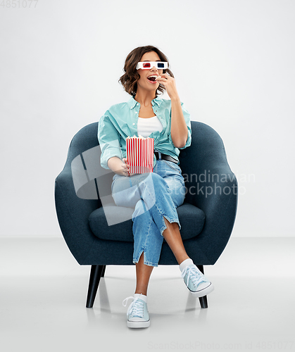 Image of woman in 3d movie glasses eating popcorn in chair