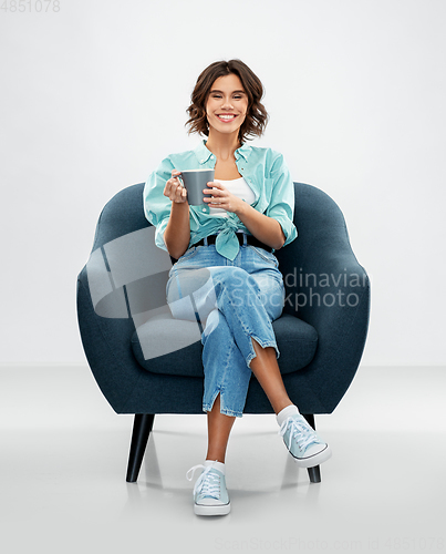 Image of woman sitting in chair with cup of coffee or tea