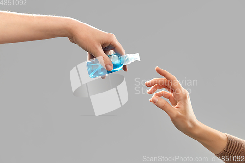 Image of close up of hands giving each other gel sanitizer