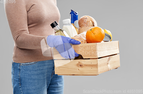 Image of woman in gloves with food in wooden box