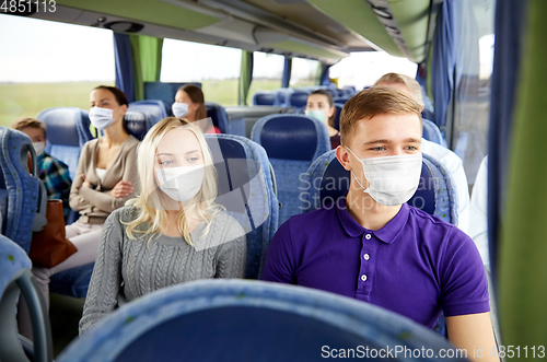 Image of couple in medical masks in travel bus