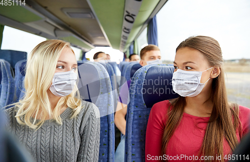 Image of young women passengers in masks in travel bus