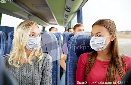 Image of young women passengers in masks in travel bus