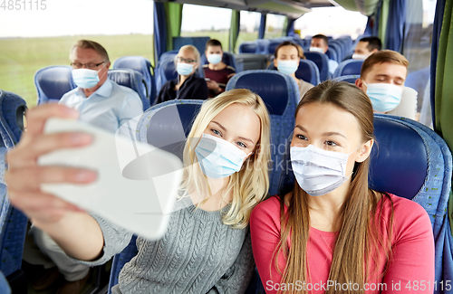 Image of women taking selfie by smartphone in travel bus