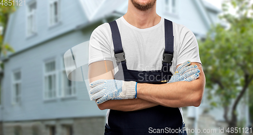 Image of close up of male builder in overall and gloves