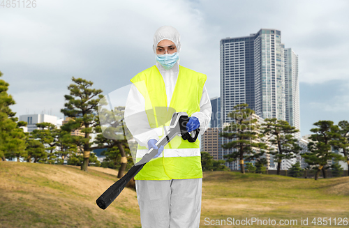 Image of sanitation worker in hazmat with pressure washer