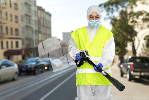 Image of sanitation worker in hazmat with pressure washer