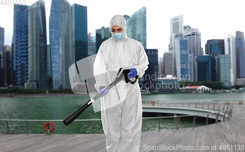 Image of sanitation worker in hazmat with pressure washer