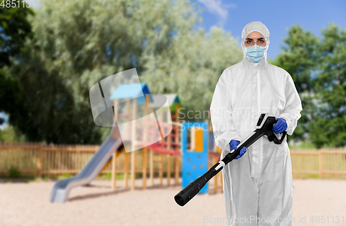 Image of sanitation worker in hazmat with pressure washer