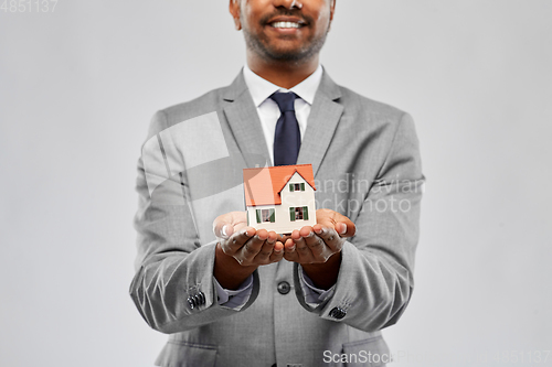 Image of close up of indian man realtor with house model