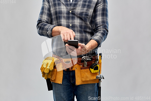 Image of worker or builder with phone and working tools