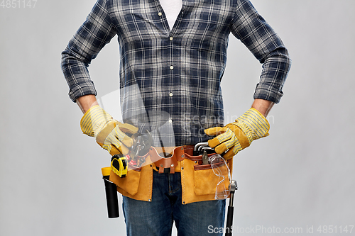 Image of builder with working tools, goggles and gloves on