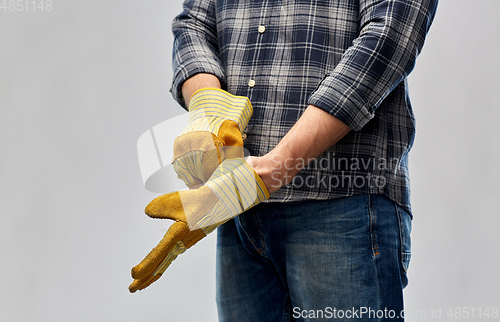 Image of man or builder putting protective gloves on