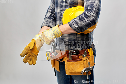 Image of builder with gloves, helmet and working tools