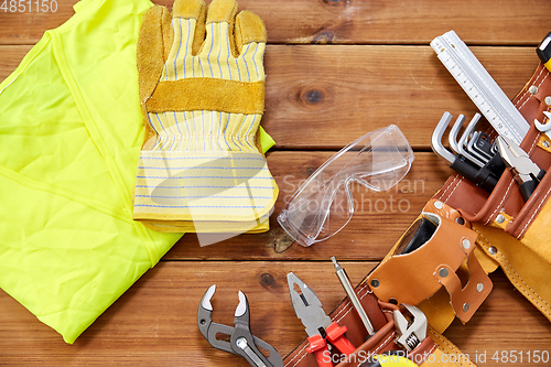 Image of different work tools in belt on wooden boards