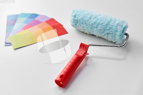 Image of paint roller and color palette on white background