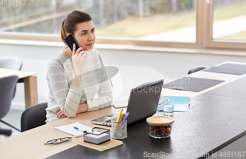 Image of young woman calling on smartphone at home office