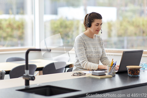 Image of woman with headset and laptop working at home