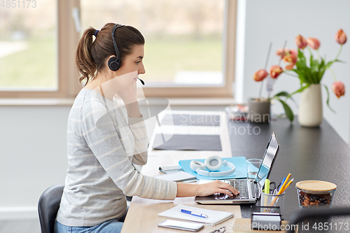 Image of woman with headset and laptop working at home