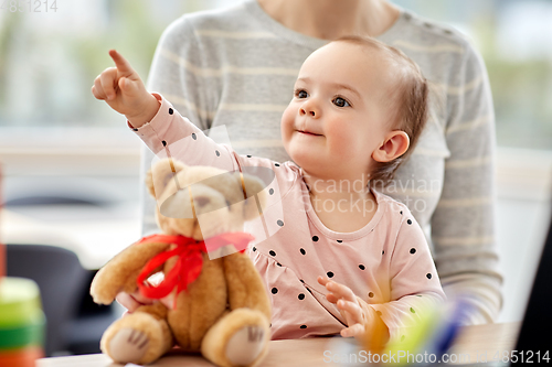 Image of happy baby with mother working at home office