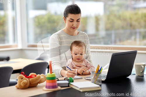 Image of mother with baby working at home office