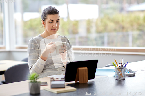 Image of young woman with tablet pc working at home office