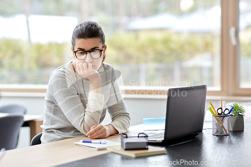 Image of bored woman with laptop working at home office