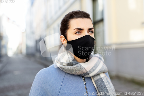 Image of woman wearing protective reusable mask in city