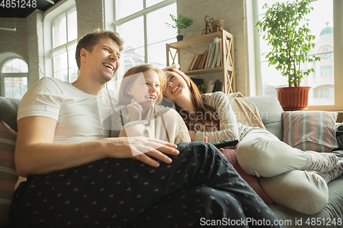 Image of Family spending nice time together at home, looks happy and cheerful, eating pizza