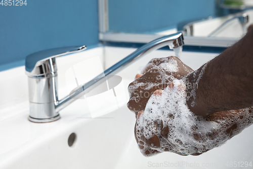 Image of Man washing hands carefully in bathroom close up. Prevention of infection and pneumonia virus spreading