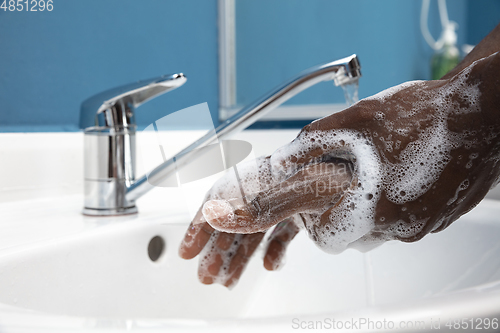 Image of Man washing hands carefully in bathroom close up. Prevention of infection and pneumonia virus spreading