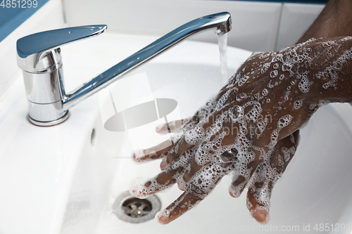 Image of Man washing hands carefully in bathroom close up. Prevention of infection and pneumonia virus spreading