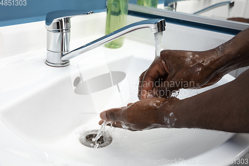 Image of Man washing hands carefully in bathroom close up. Prevention of infection and pneumonia virus spreading