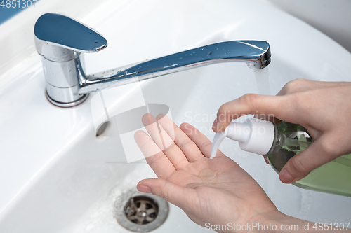 Image of Woman washing hands carefully in bathroom close up. Prevention of infection and pneumonia virus spreading