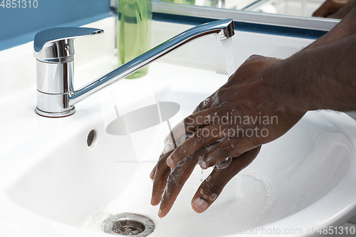 Image of Man washing hands carefully in bathroom close up. Prevention of infection and pneumonia virus spreading