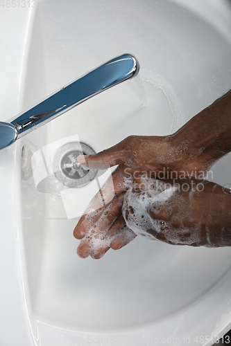 Image of Man washing hands carefully in bathroom close up. Prevention of infection and pneumonia virus spreading