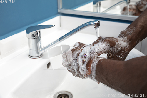 Image of Man washing hands carefully in bathroom close up. Prevention of infection and pneumonia virus spreading