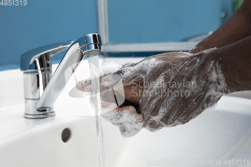 Image of Man washing hands carefully in bathroom close up. Prevention of infection and pneumonia virus spreading